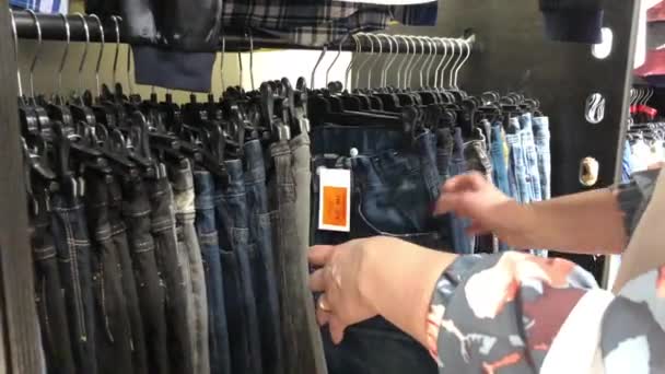 Zakupy Sklepie Odzieżowym Kobieta Wybiera Ubrania Które Wiszą Wieszaki — Wideo stockowe