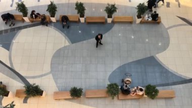 İnsanlar dükkanda dolaşıyor. Alışveriş merkezindeki insanların hareketi. Yukarıdan görüntüle.