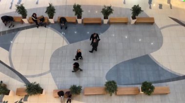 İnsanlar dükkanda dolaşıyor. Alışveriş merkezindeki insanların hareketi. Yukarıdan görüntüle.