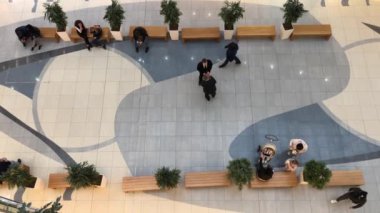 İnsanlar dükkanda dolaşıyor. Alışveriş merkezindeki insanların hareketi. Yukarıdan görüntüle.