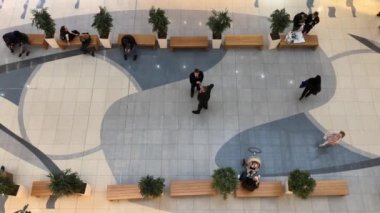 İnsanlar dükkanda dolaşıyor. Alışveriş merkezindeki insanların hareketi. Yukarıdan görüntüle.