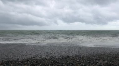 Denizde fırtına, sahilde fırtına uyarısı. Fırtına sırasında gök gürültülü bulutlar ve büyük deniz dalgaları. Gürcistan'da Karadeniz'de büyük fırtına dalgaları karaya vurdu.