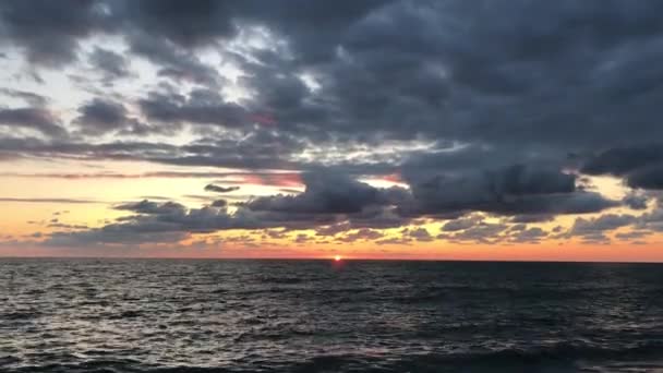 ビーチからの眺め 海の美しい夕日 太陽の光が雲を貫通する 海の夏の夕方 暗い雲を持つ空 太陽が水に反射される — ストック動画