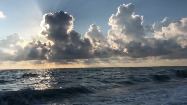 美丽的日落在海上 从海滩景色 太阳的光线穿透云层 夏夜在海上 蓝天白云 太阳映入水中 海浪拍打着海岸 — 图库视频影像