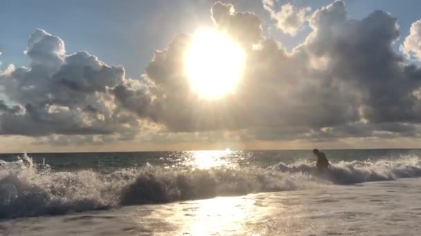 美丽的日落在海上 从海滩景色 太阳的光线穿透云层 夏夜在海上 蓝天白云 太阳映入水中 海浪拍打着海岸 — 图库视频影像