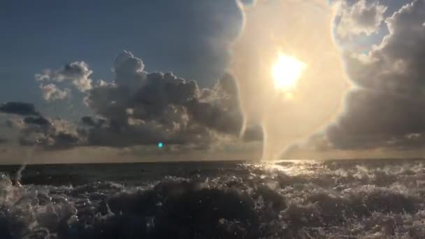 ビーチからの眺め 海の美しい夕日 太陽の光が雲を貫通する 海の夏の夕方 雲と青い空 太陽が水に反射され 波が海岸に打ち寄せる — ストック動画