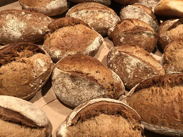 Много испеченного круглого хлеба. Свежий хлеб на полке. Фоновая текстура: хлеб насущный . — стоковое фото