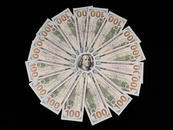 Sedlar på 100 US dollar ligger i en cirkel. Bilden av Benjamin Franklin är omgiven av hundradollarsedlar. Amerikanska pengar på bordet. — Stockfoto