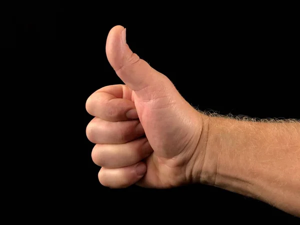 Hüvelykujj fel, fekete háttérrel. Egy gesztus egy ujjal, a jóság jele.. — Stock Fotó