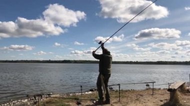 Balıkçı gölde bir tur attı. Bir adam nehir kenarında balık tutuyor. Elinde olta olan bir adam gölde balık yakalar..