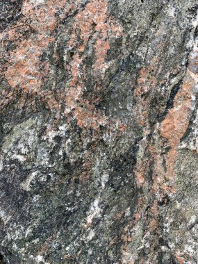 Arkaplan dokusu: büyük bir taşın yapısı. Granit kaya, yakın çekim. Taş kayalarda düzensizlikler ve çatlaklar var. Kavram - taş, sertlik, güç