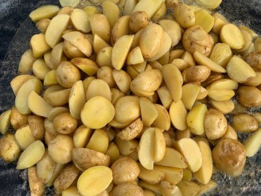 Ateşin üstünde patates kızartması. Doğada piknik, yemek ateşte hazırlanır. Izgara taze patates ve duman. Açık hava yemekleri..