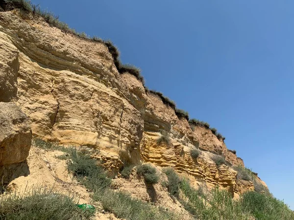 Denizin kıyısındaki dağın dik yamacında. Okyanus kıyısındaki kum dağı. Deniz tepesi kıyıya yakın.