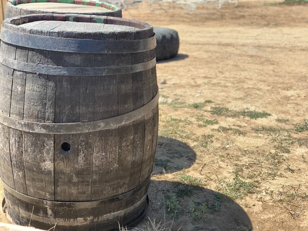 Wooden oak barrels with a metal rim. Wooden barrel with a hole. Capacious containers for water and other liquids.