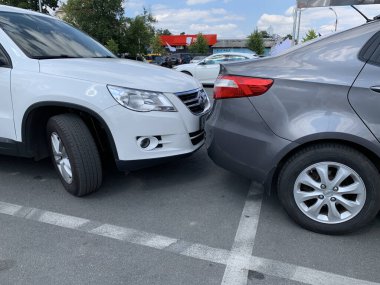 Yan yana iki araba. Arabalar çok yakında park edilmiş. Tampondan tampona küçük bir boşluk. Irpen, Kiev bölgesi, süpermarket otoparkı, 23 Ağustos 2020.