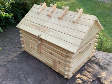 Taşın üzerinde minyatür ahşap bir ev. Kayanın üzerindeki küçük oyuncak evi. Sağlam bir temelde ahşap bir ev modeli..