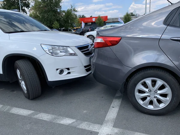 Yan yana iki araba. Arabalar çok yakında park edilmiş. Tampondan tampona küçük bir boşluk. Irpen, Kiev bölgesi, süpermarket otoparkı, 23 Ağustos 2020.