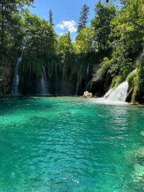 Hırvatistan 'ın büyüleyici Plitvice Göllerini keşfedin, şelalelerin üzerinden akan turkuaz suların doğanın başyapıtında unutulmaz bir yolculuk yarattığı.