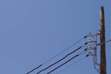 Mavi gökyüzünün önündeki güç kaynağı hattı