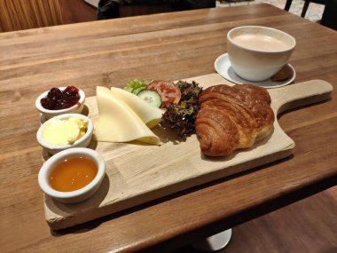 Fransız kahvaltısı ahşap bir tahtada servis edilir.