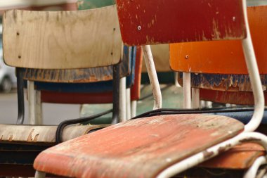 Birkaç eski yıpranmış sandalye yığılmış ve sokağa bırakılmış.