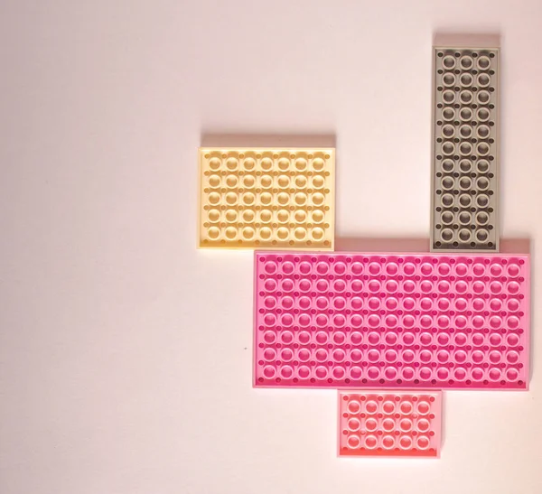 Constructor rosa sobre fondo blanco. Textura. Concepto de minimalismo, plano, vista superior, fondo — Foto de Stock