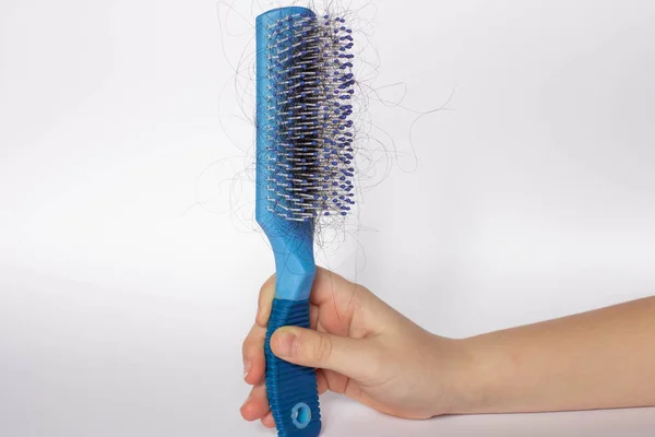 Hair fall out. Hairbrush with hair on a white background. Comb in hand. — Stock Photo, Image