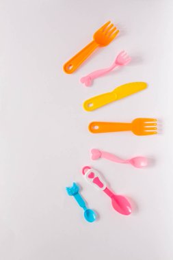 Çocuk beyaz bir arka plan, çatal, kaşık, plastik yemeklerden plaka ile metin için yer. Düz yatıyordu, en iyi görünüm çok az kavramı.