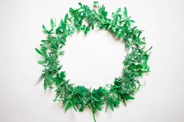 Menekşe beyaz zemin üzerinde bir çelenk. Yuvarlak kare mor çiçekler ve taze ot. Yaz çiçek. Düz yatıyordu, en iyi görünümü.