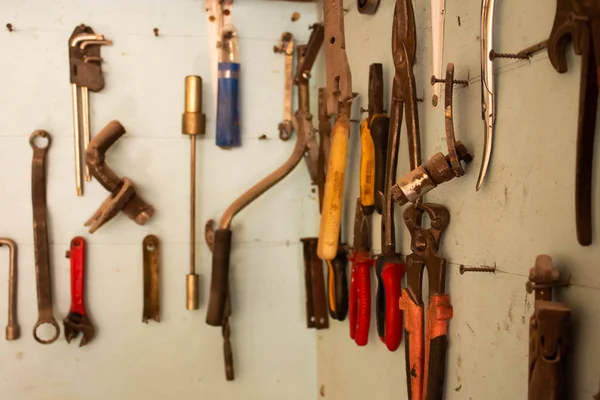 keys in the garage tools. Old tools hanging on wall in workshop , Tool shelf against a wall  in the garage