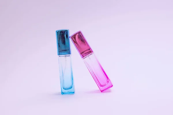 Glass bottle of perfume on white background. Pink, blue, green, black bottle. Women's and men's perfume. Aromatherapy, spa. — Stockfoto