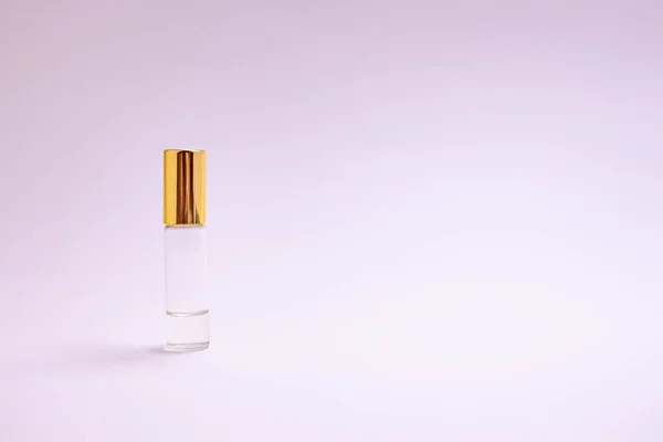 Testeur de parfum. Petite bouteille en verre de parfum avec capuchon en or. Texte spatial. Le concept de minimalisme. maquette . — Photo