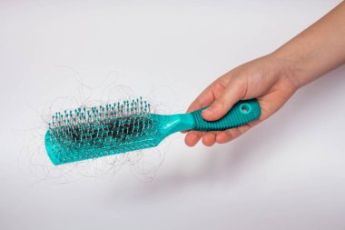 Kız saçlar beyaz arka planda bir tarak ve sorun saç ile düşer. Saç düşüşü veya allık ile kaybı kadınların bir sorundur.