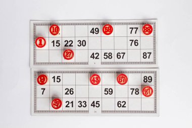 Bingo ya da loto oyunu. Kartlar üzerinde Loto Ahşap fıçılar. Beyaz bir masada Bingo oynamak için kartlar ve cips