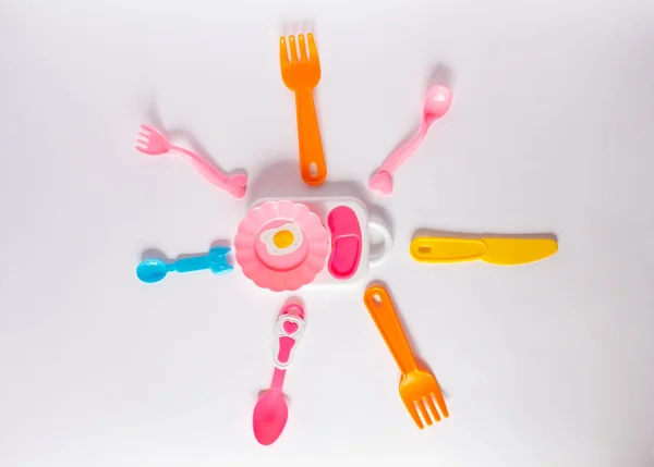 Muitos garfos plásicos coloridos, colheres e facas no fundo branco com espaço de cópia, vista superior. Dispositivos para alimentos para bebés — Fotografia de Stock
