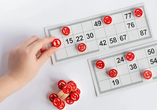 Bingo o juego de lotería. barriles de madera de lotería en las tarjetas. Tarjetas y fichas para jugar bingo en una mesa blanca — Foto de Stock