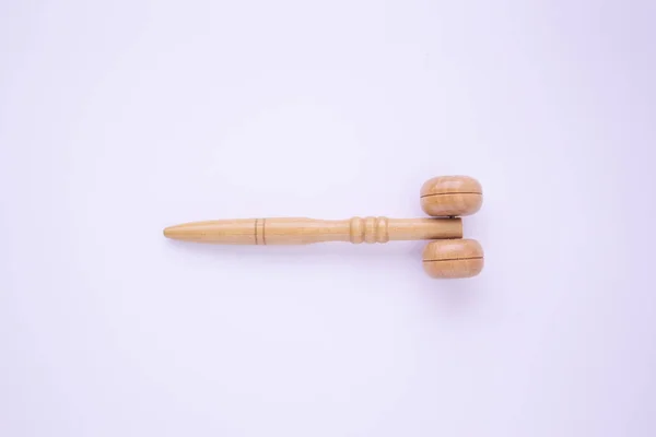 Wooden roller for the face for a cosmetic massage - skin care for women, rubbing oils and cream on a white background. Top view