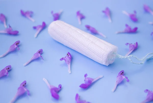 O conceito do período menstrual. Protecção da higiene feminina. Tampões de algodão num fundo azul. Vista superior, flat lay . — Fotografia de Stock