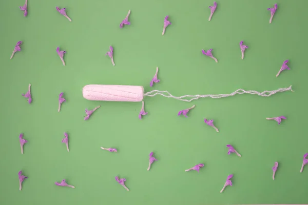 Het concept van de menstruatiecyclus, menstruatie en intieme producten met een interne wattenstaafje, op groene achtergrond met Kopieer ruimte — Stockfoto