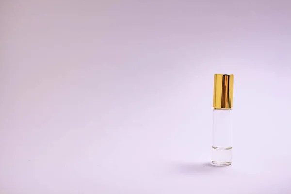 Perfume tester. Small perfume glass bottle with gold cap. Space text. The concept of minimalism. mockup. — Stock Photo, Image