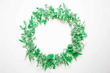 Menekşe beyaz zemin üzerinde bir çelenk. Yuvarlak kare mor çiçekler ve taze ot. Yaz çiçek. Düz yatıyordu, en iyi görünümü.