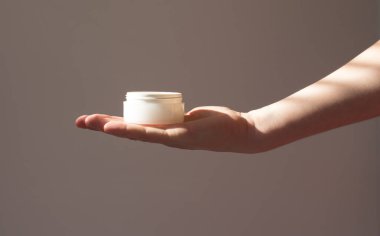  Kadın eli kozmetik ürünleri beyaz bir tüpte tutuyor, yaşlanma önleyici, doğal eko kozmetik ürünler..