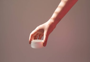  Kadın eli kozmetik ürünleri beyaz bir tüpte tutuyor, yaşlanma önleyici, doğal eko kozmetik ürünler..