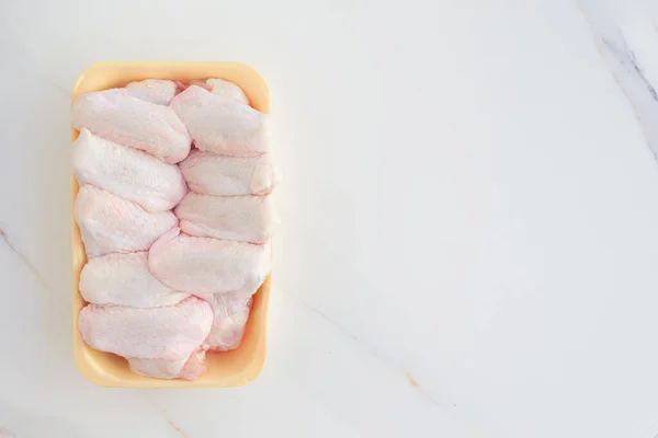 Холодные Куриные Крылышки Желтом Подносе Свежее Мясо Магазина Белом Столе — стоковое фото
