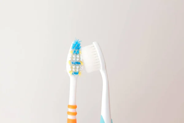 Red and blue toothbrushes on a gray background. Old and new toothbrush. Oral hygiene concept. copy space for text — Stock Photo, Image