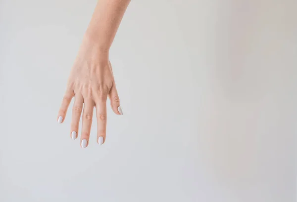 Mano Femenina Con Una Hermosa Manicura Sobre Fondo Una Pared — Foto de Stock