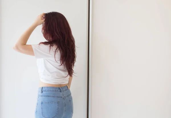 白いTシャツとジーンズの中に豪華な髪の女の子 広告シャンプー ヘアマスクのためのバナー 女は髪を — ストック写真