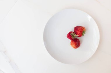  Beyaz terelka içinde ev bahçesinden alınmış iştah açıcı çilek ve fotokopi alanı. Çilek ve kırmızı böğürtlen hasat mevsimi. Dokunulmazlığı arttırmak için çileksiz alerji.