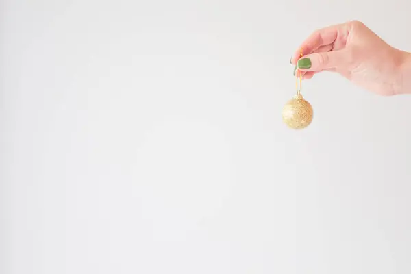 Bola Natal Dourada Mão Uma Jovem Mulher Zombar Fundo Branco — Fotografia de Stock