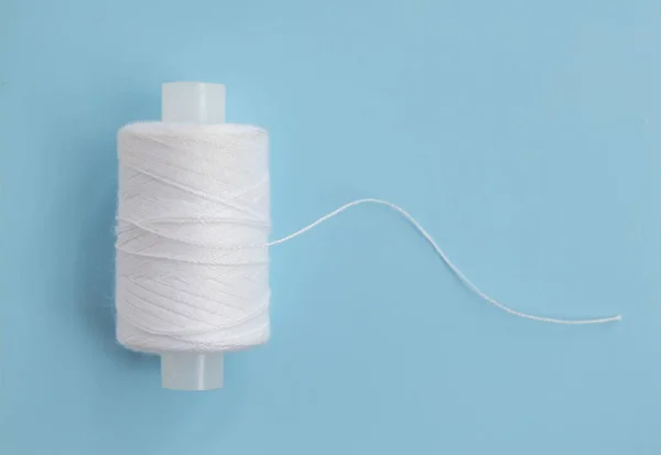 コピースペースとブルーの縫製糸のクローズアップ 糸は綿でできており 衣服の生産のための合成繊維で作られています — ストック写真